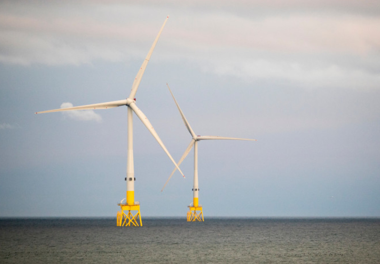 Photo of two wind turbines in the ocean