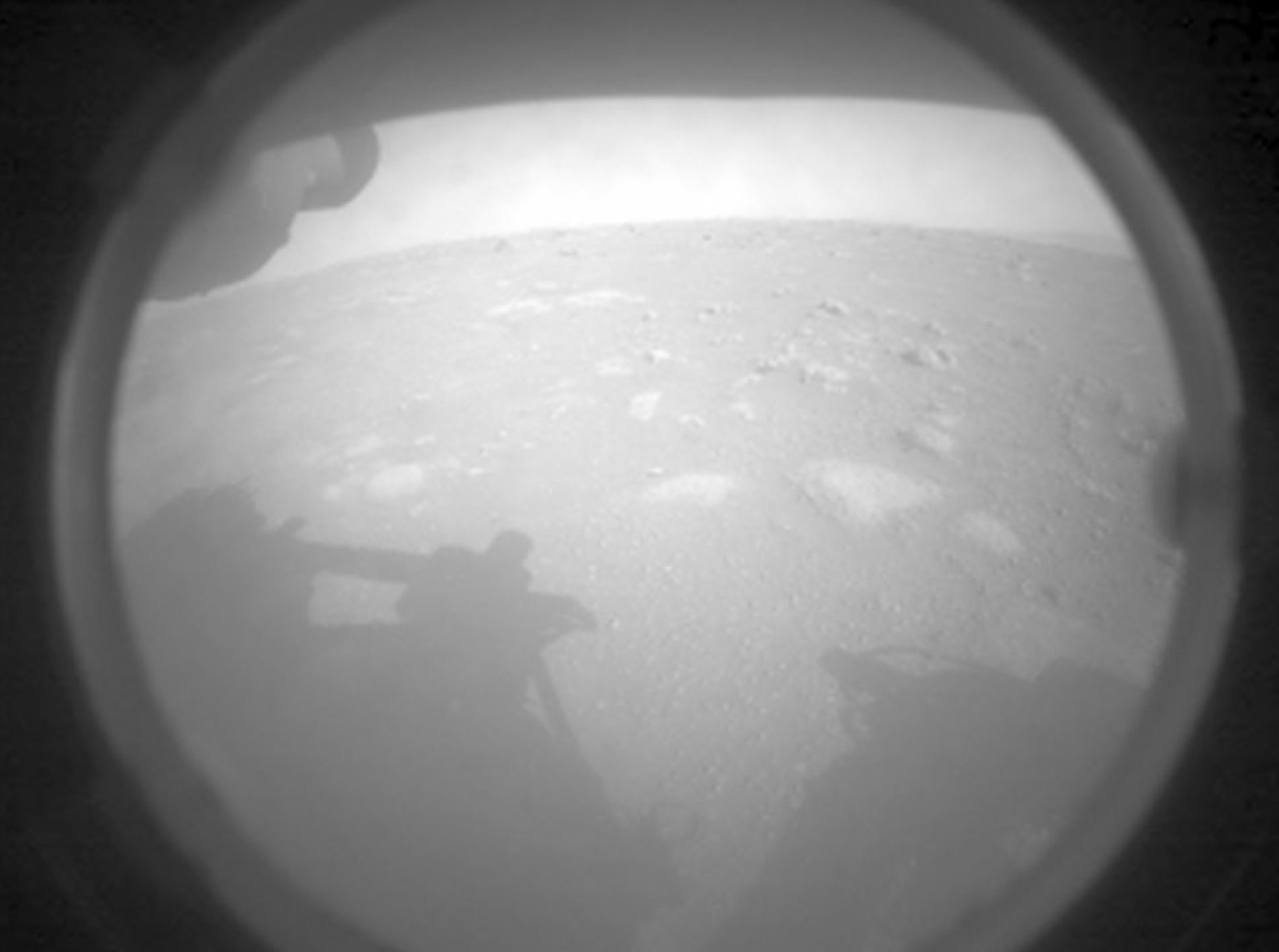 Black and white photo of a rocky landscape with a shadow of the rover