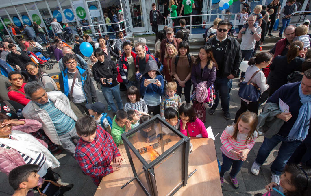 A crowd looks at a fire experiment