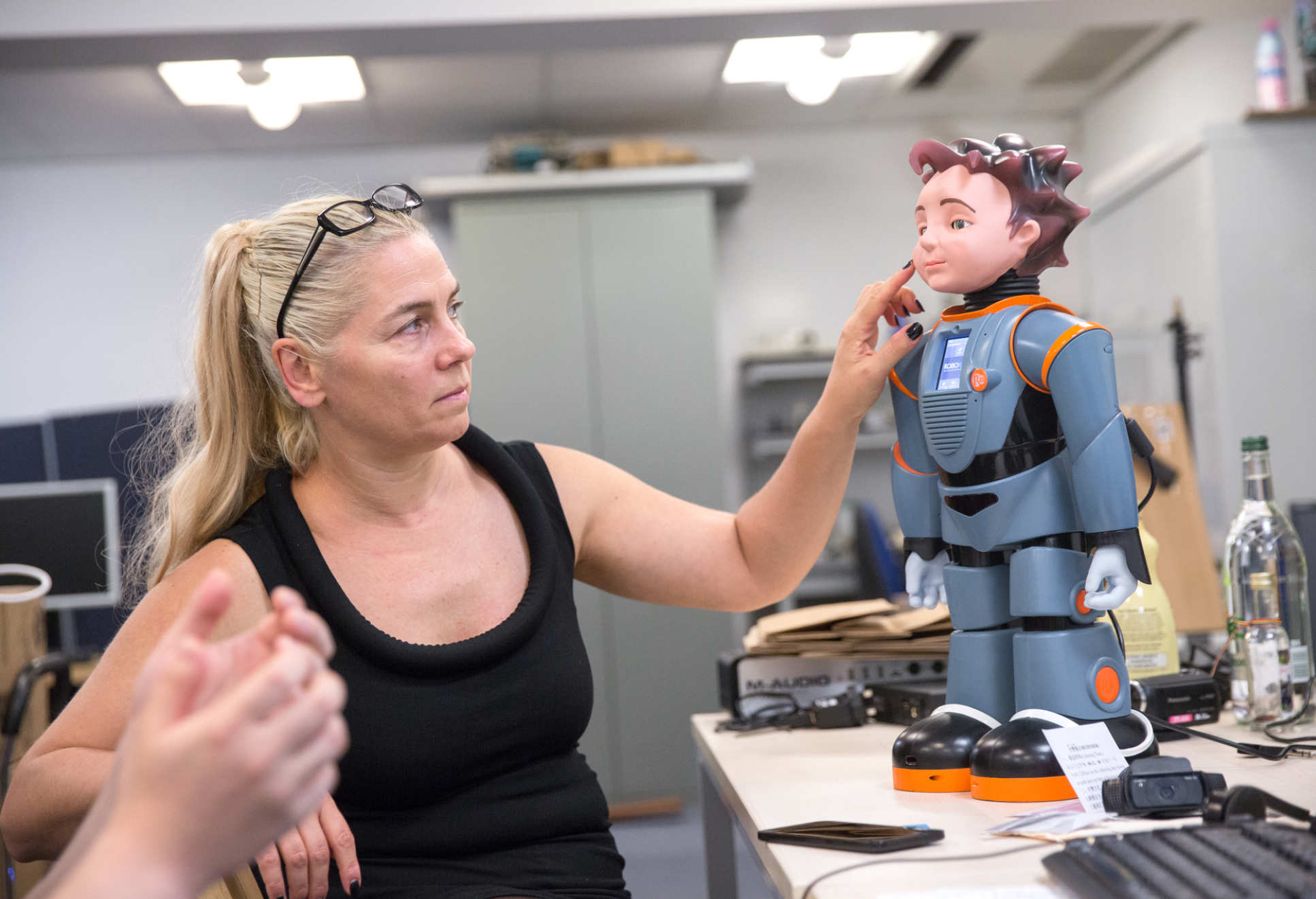 Professor Maja Pantic points at her robot