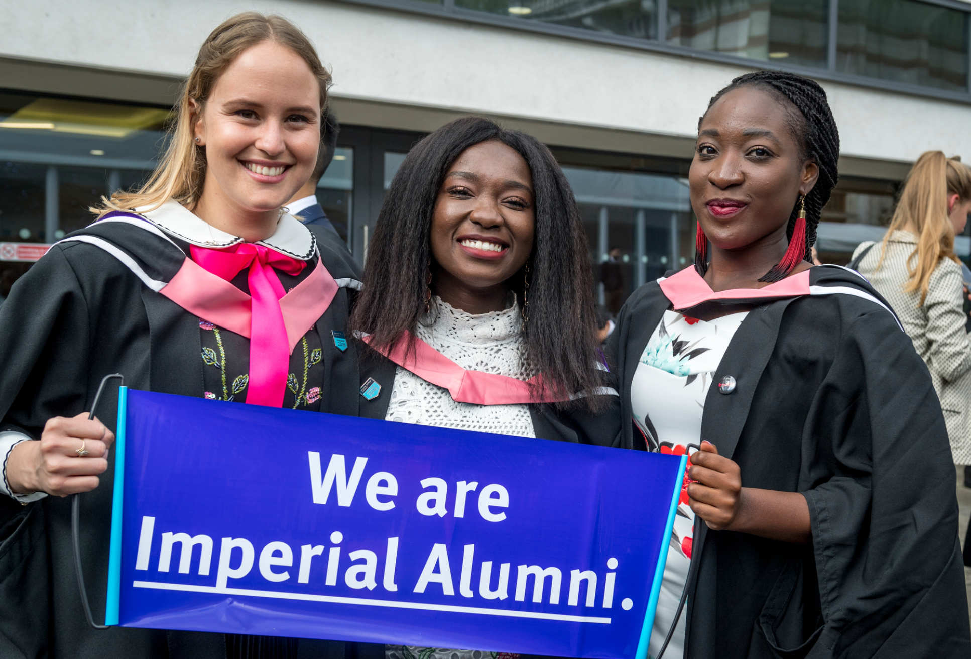 Students hold up 'We are Imperial Alumni' sign