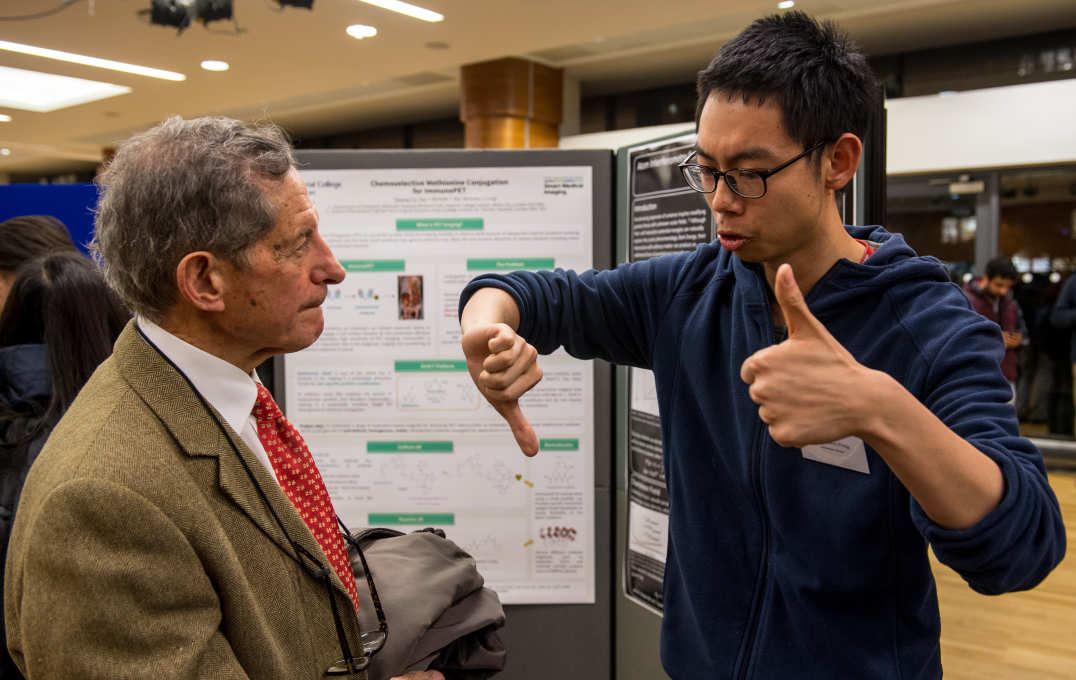 A student with one thumb up and one thumb down to explain his work