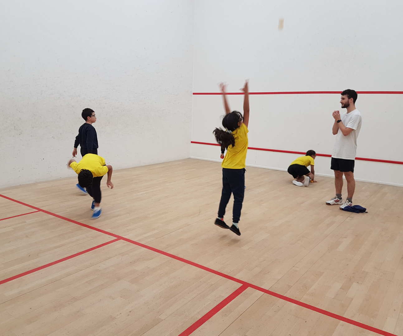 Children with teacher playing squash