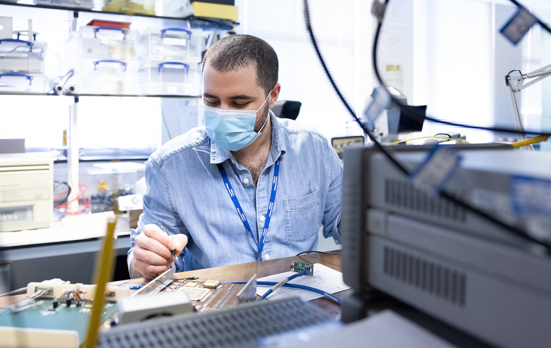 A man working on electronics at a lab bench