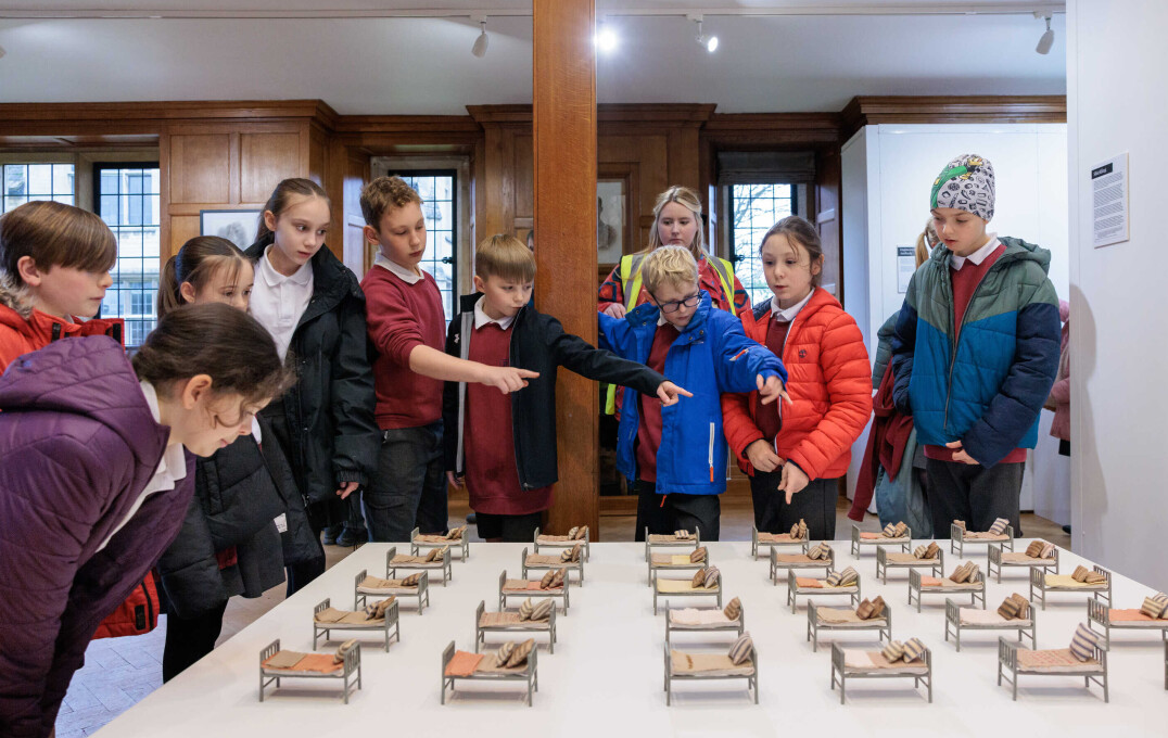 Children pointing at an art instillation, made of mini beds