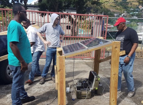 Installation of seismic stations on the island with University of the West Indies collaborators. Image shows three men with the seismometer.