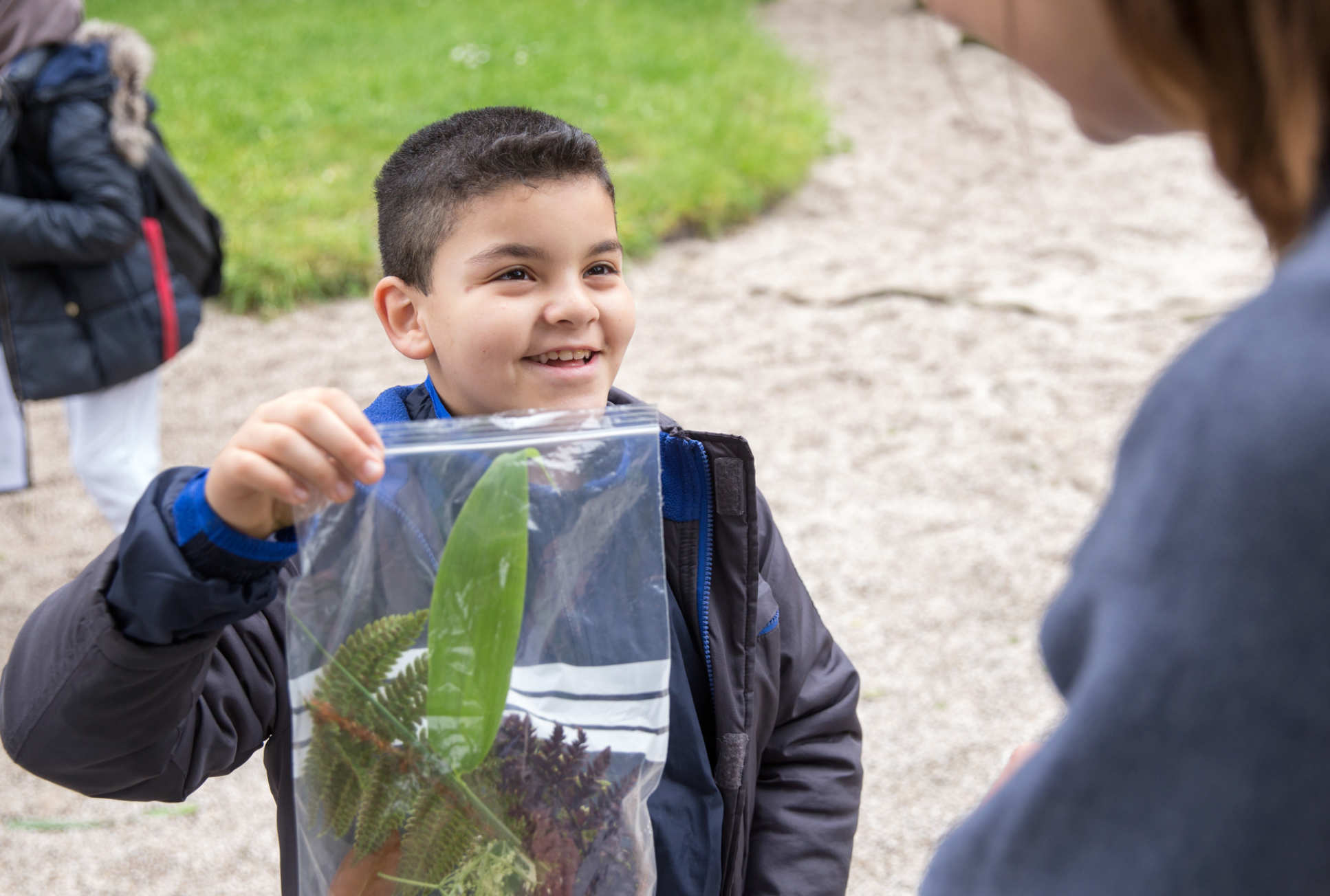 Child holding a bag of leaves