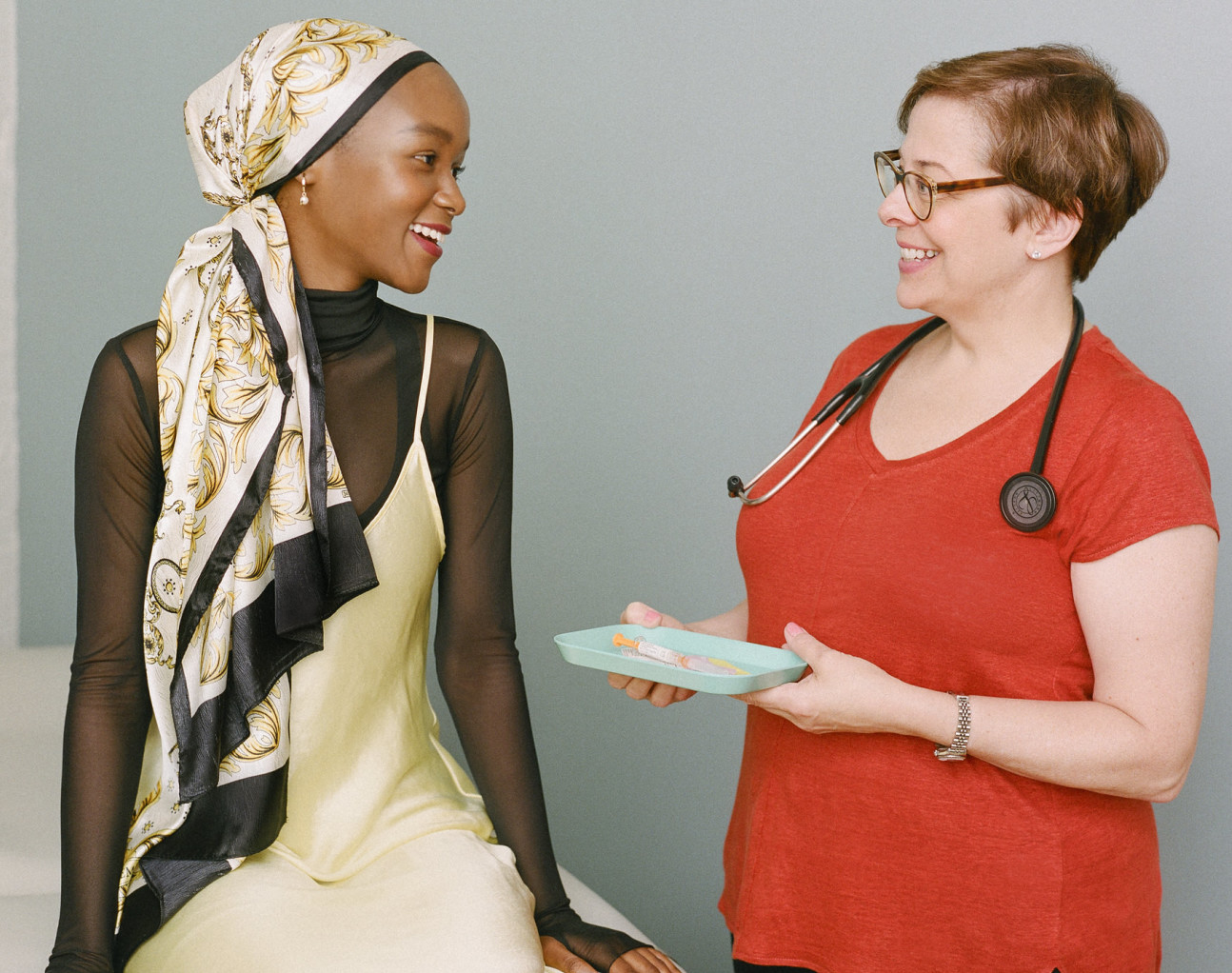 Doctor approaching woman with vaccine on a tray