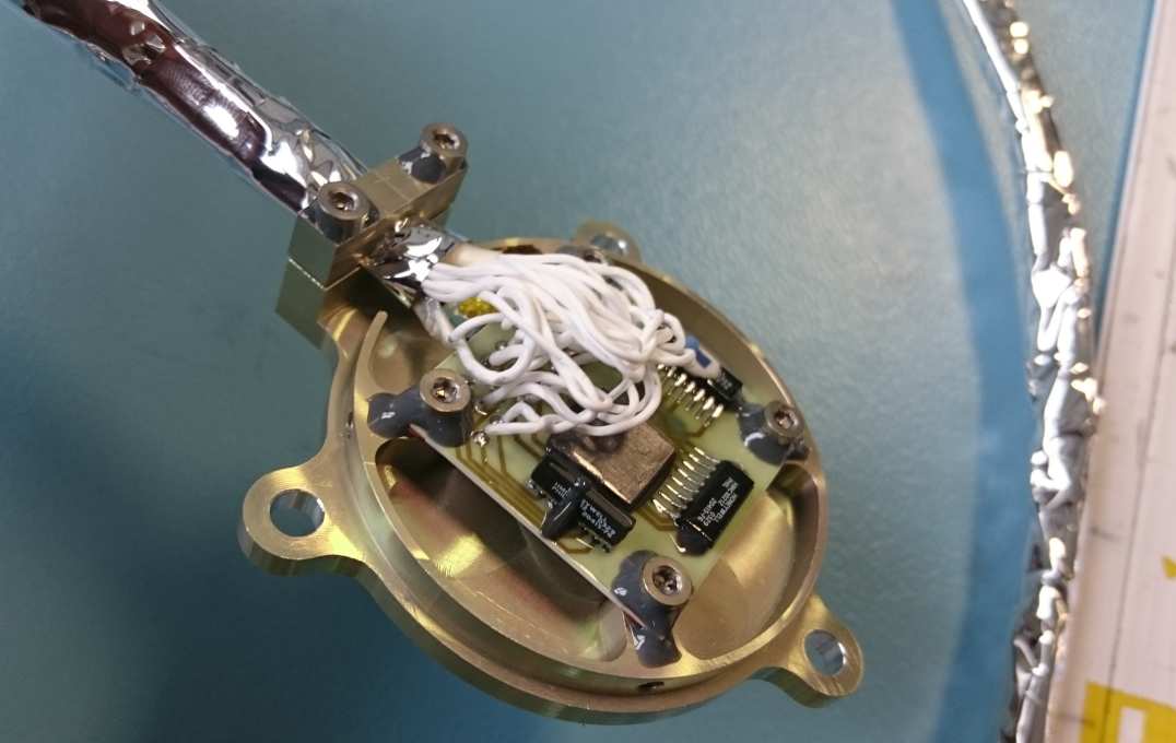 The square circuit board attached to a round mount and some wires