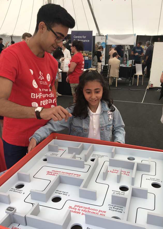 Child plays game with British Heart Foundation volunteer