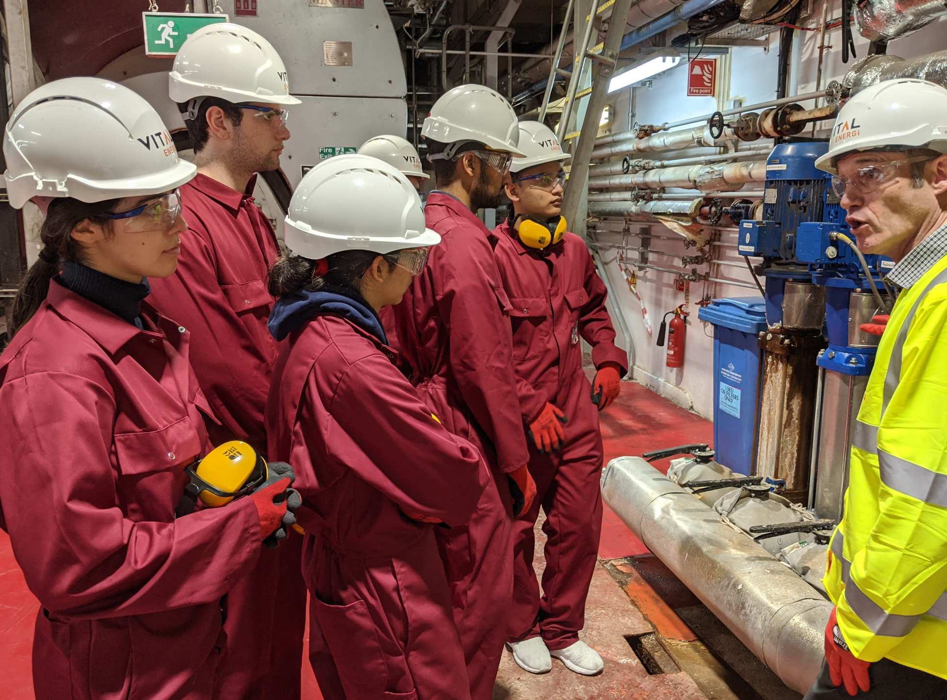 Students in the plant listening to an expert