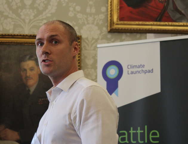 A man presents in front of sign that reads "climate launchpad"