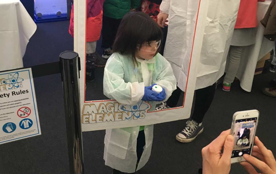 person takes camera-phone shot of little girl dressed as a scientist