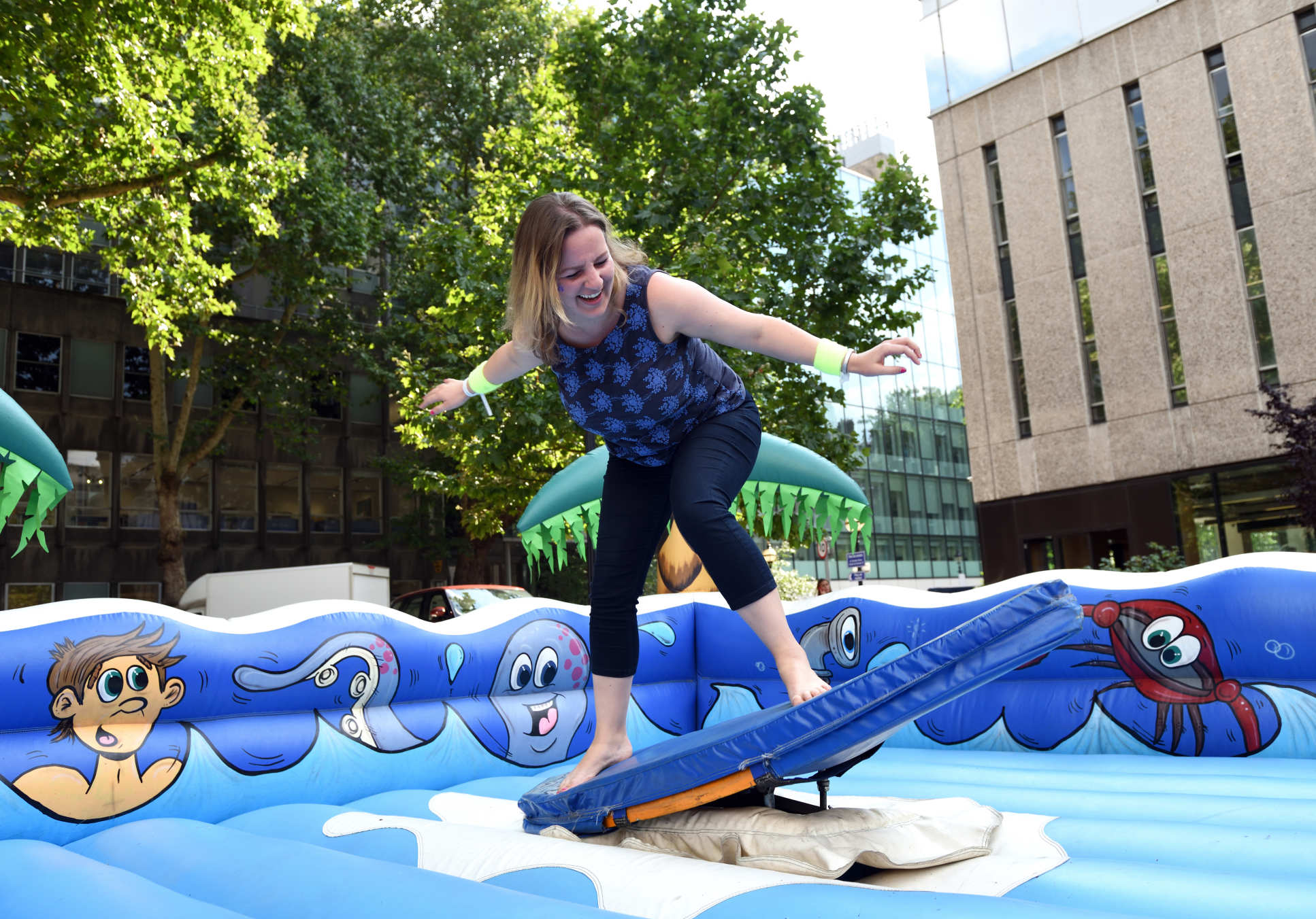 A staff member tries out surfing on an inflatable surfboard
