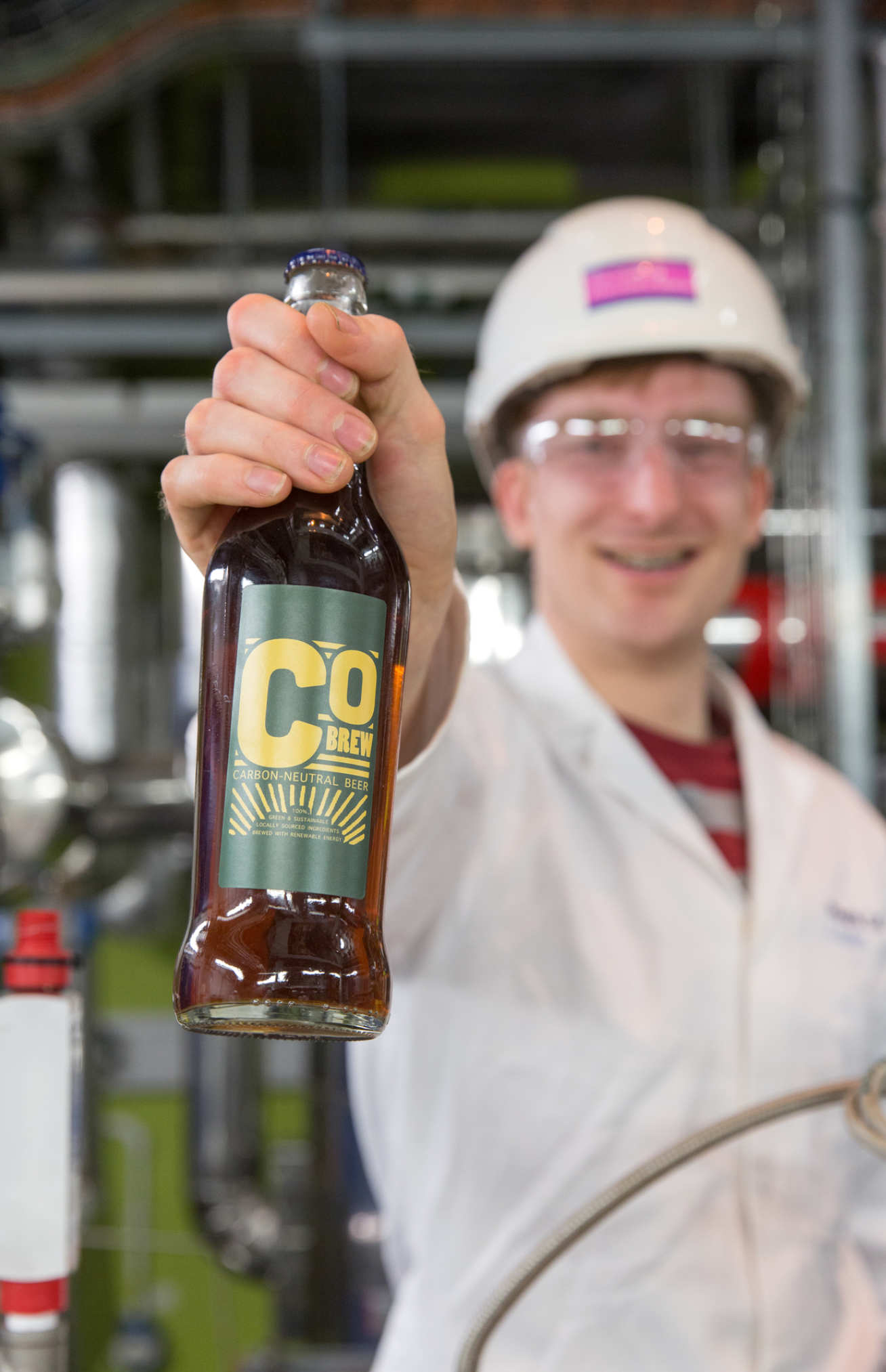 Matt Barker holds a bottle of the CObrew beer in the Carbon Capture Pilot Plant
