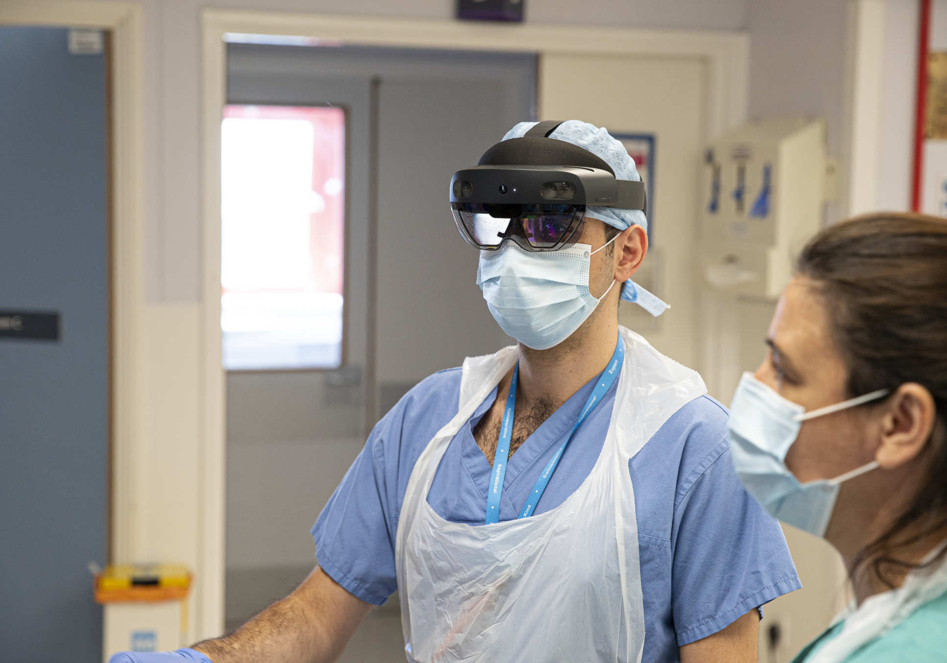 A photogrph of two doctors, one wearing a HoloLens headset