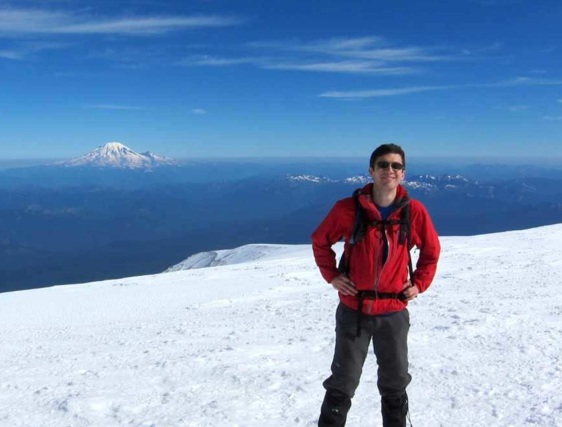 Dr Ceppi on top of Mount Adams, with Mt Rainier in the background 