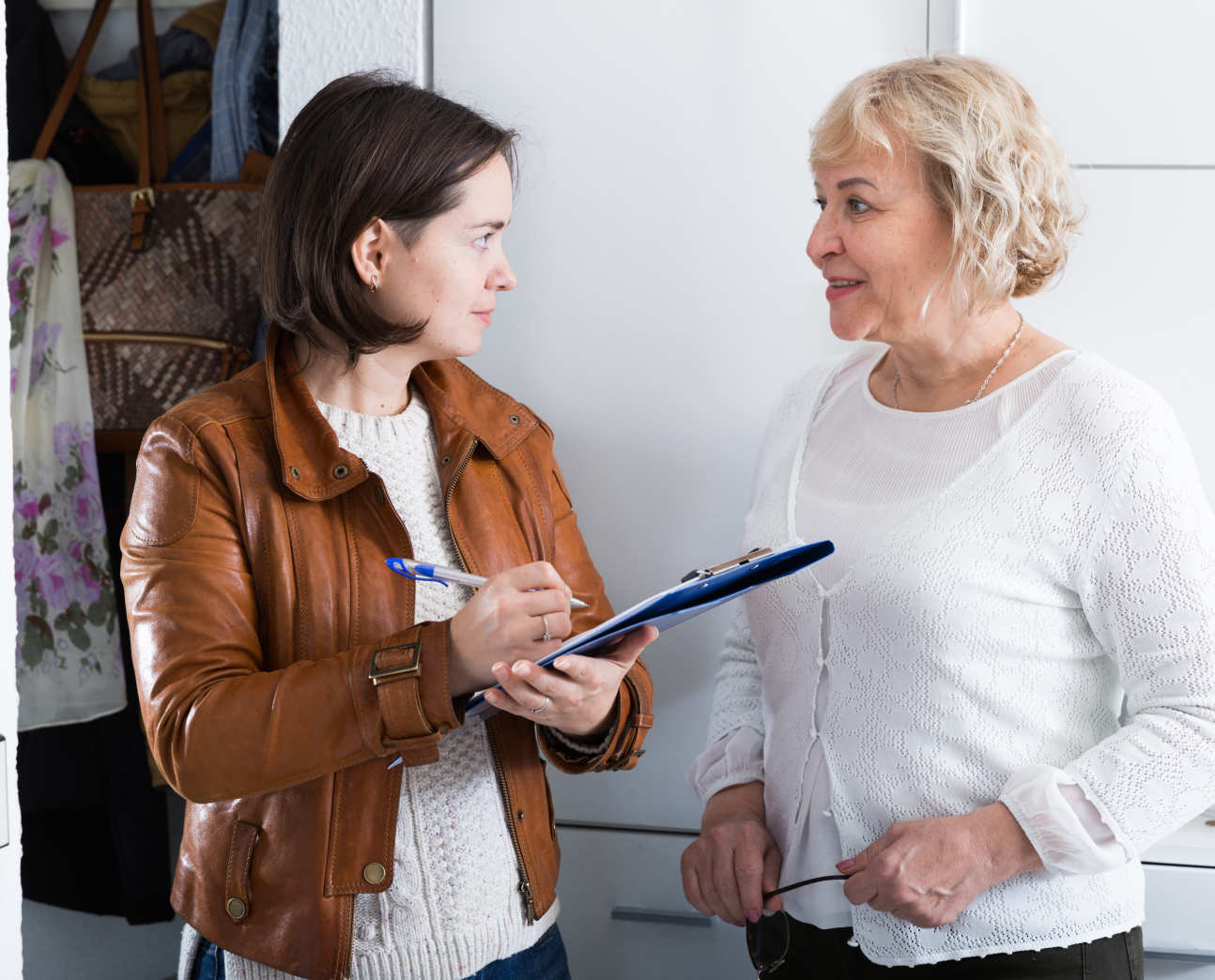 A woman with a clipboard interviewing another woman