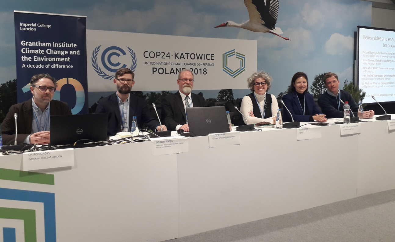 Four men and two women form a panel in front of a sign reading "COP24 Katowice" 
