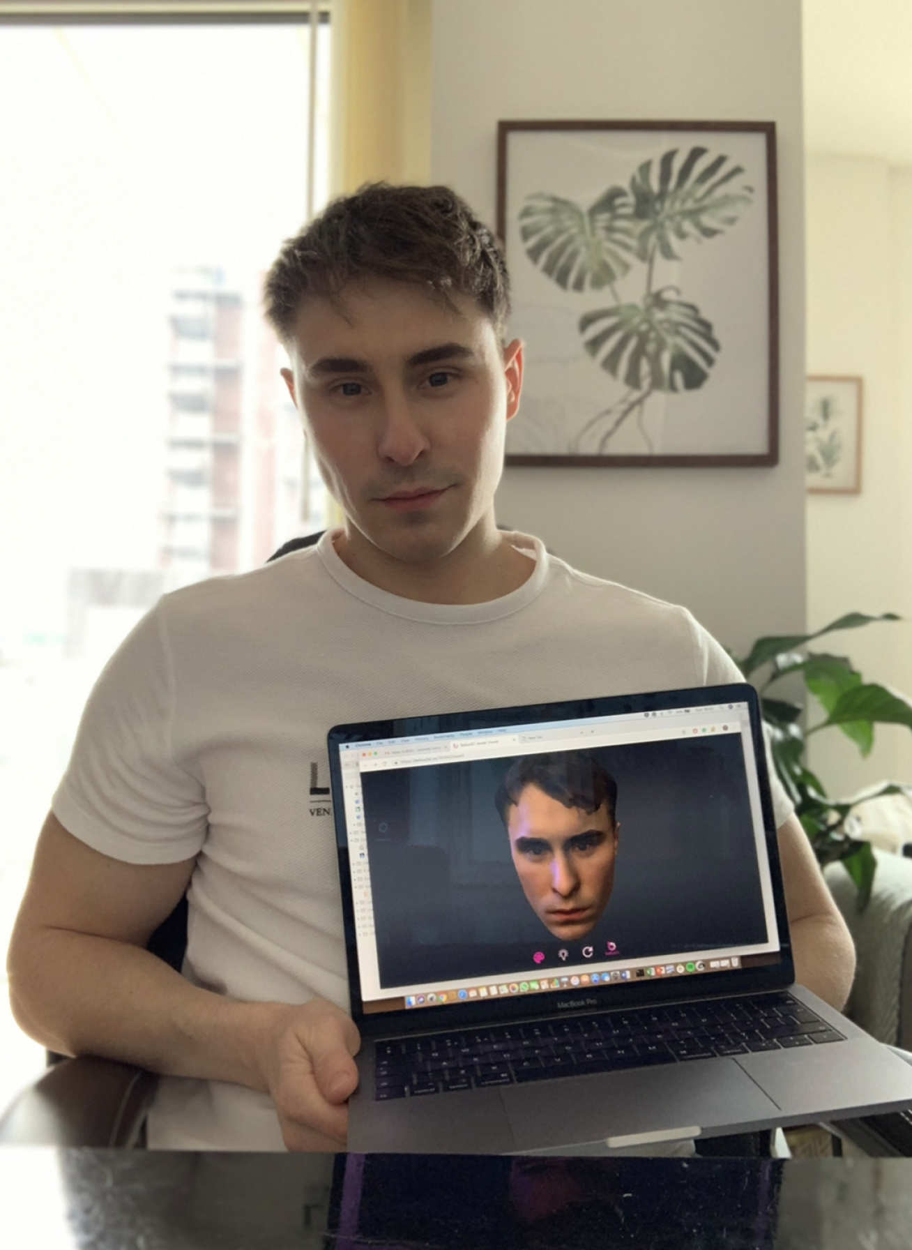 PhD student Tom Versluys holding a computer scan image of his face