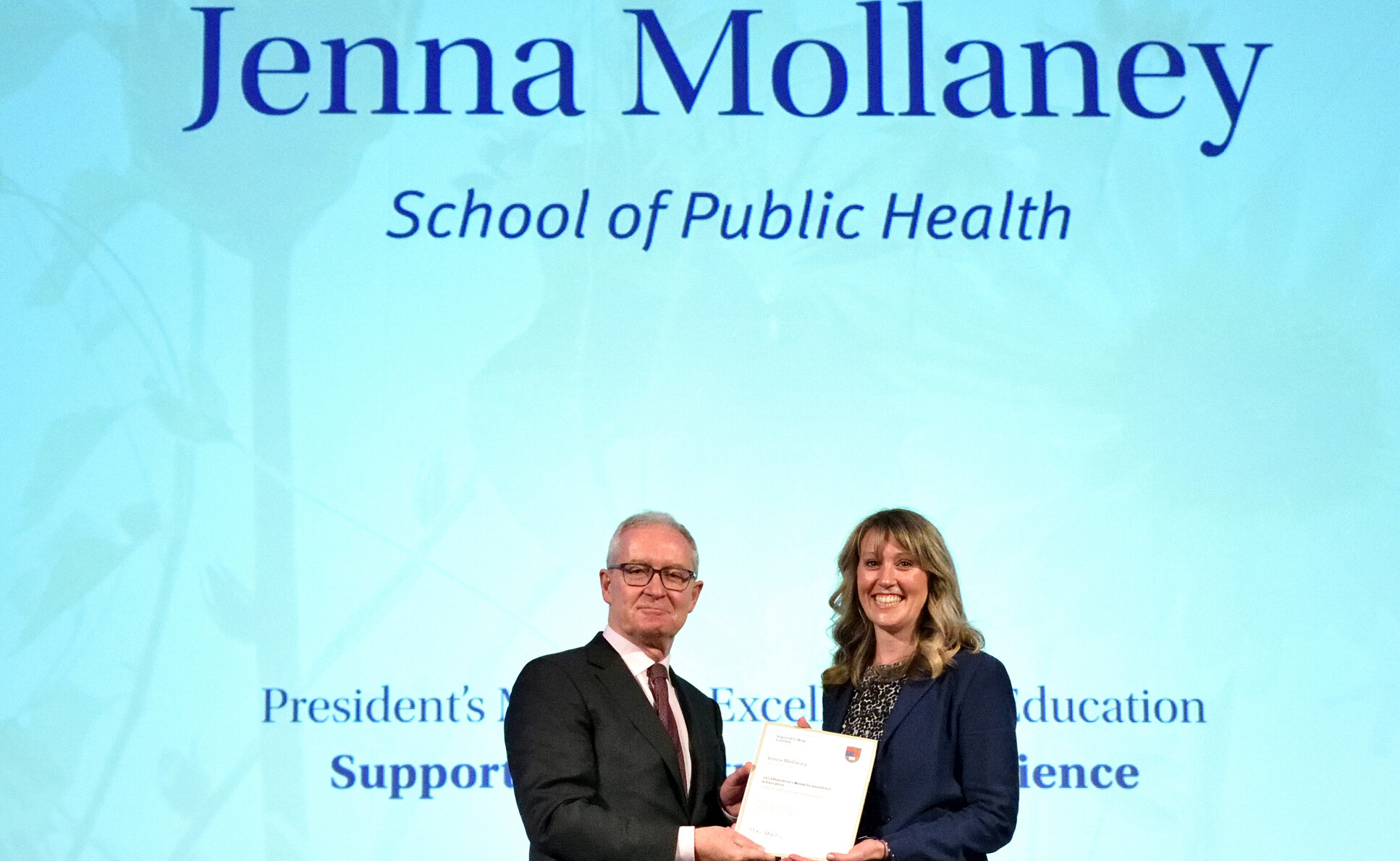 Jenna Mollaney receiving an award from President Hugh Brady