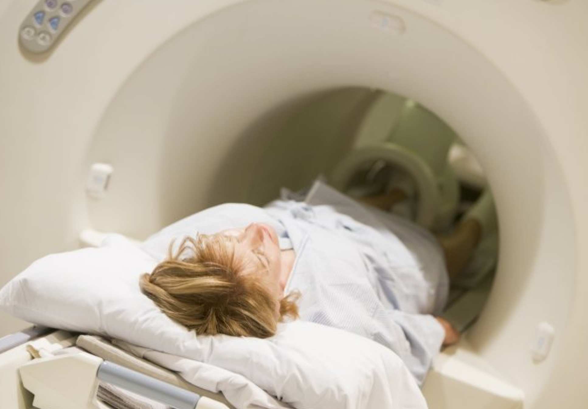 Woman lying flat inside CT scanner