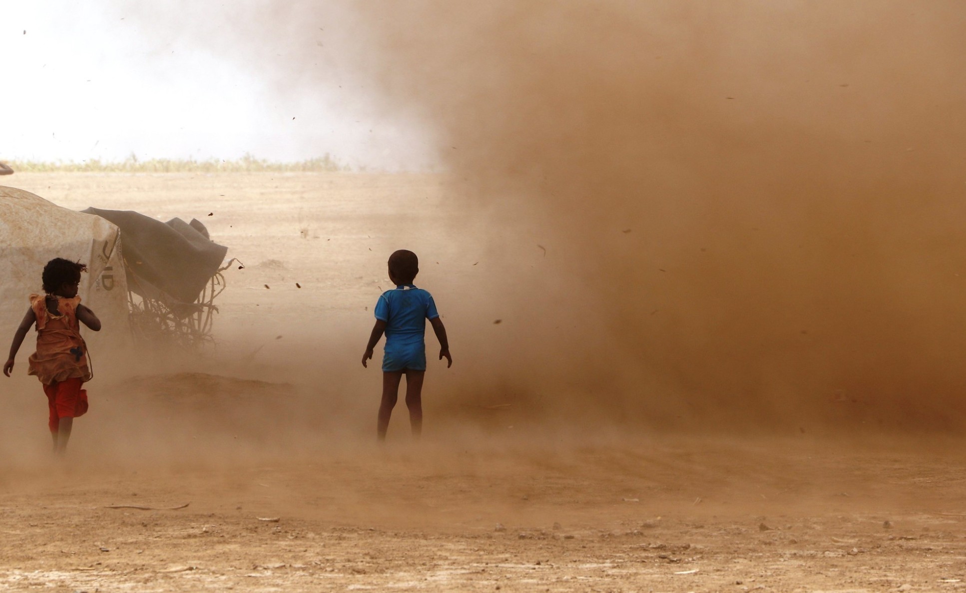 Two children in a dusty landscape