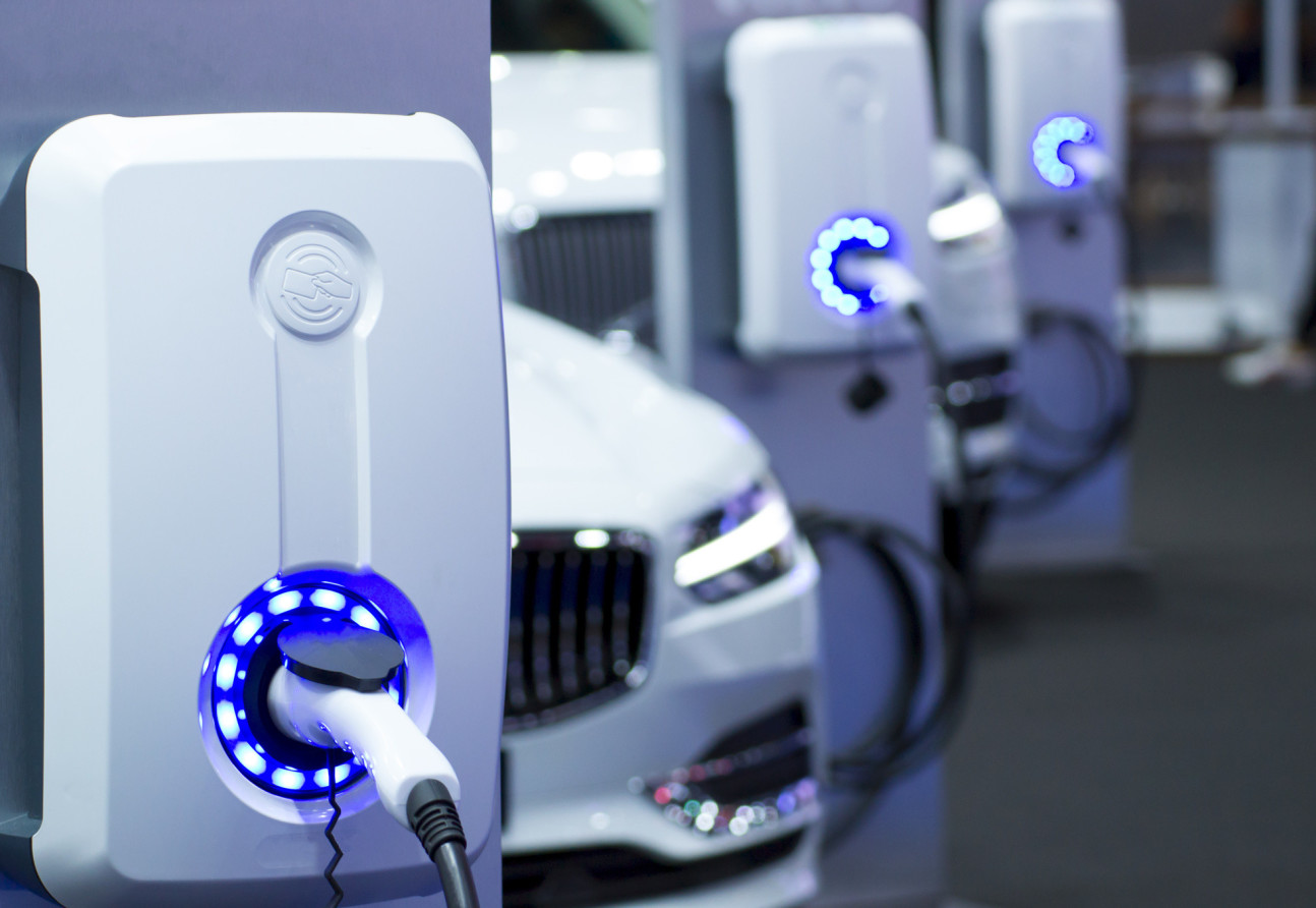 Electric cars in a row with plugs