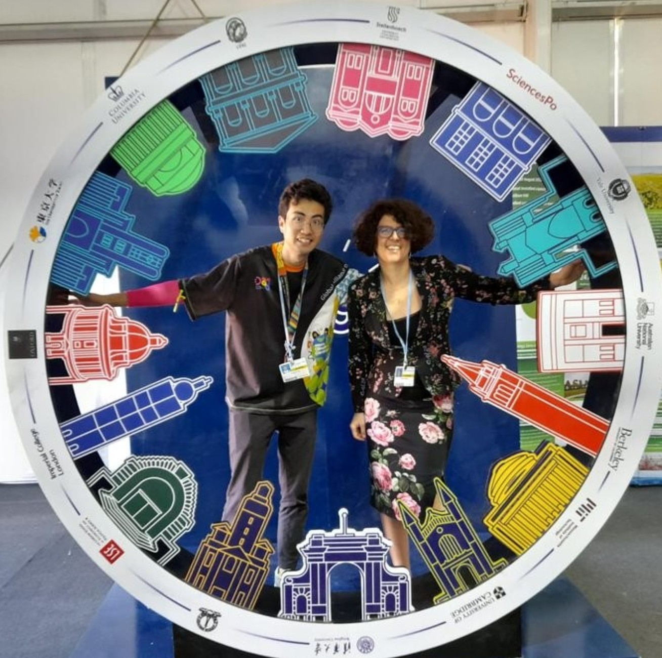 Fangjun Peng and Alyssa Gilbert stand in a cut-out circle that represents universities attending COP27