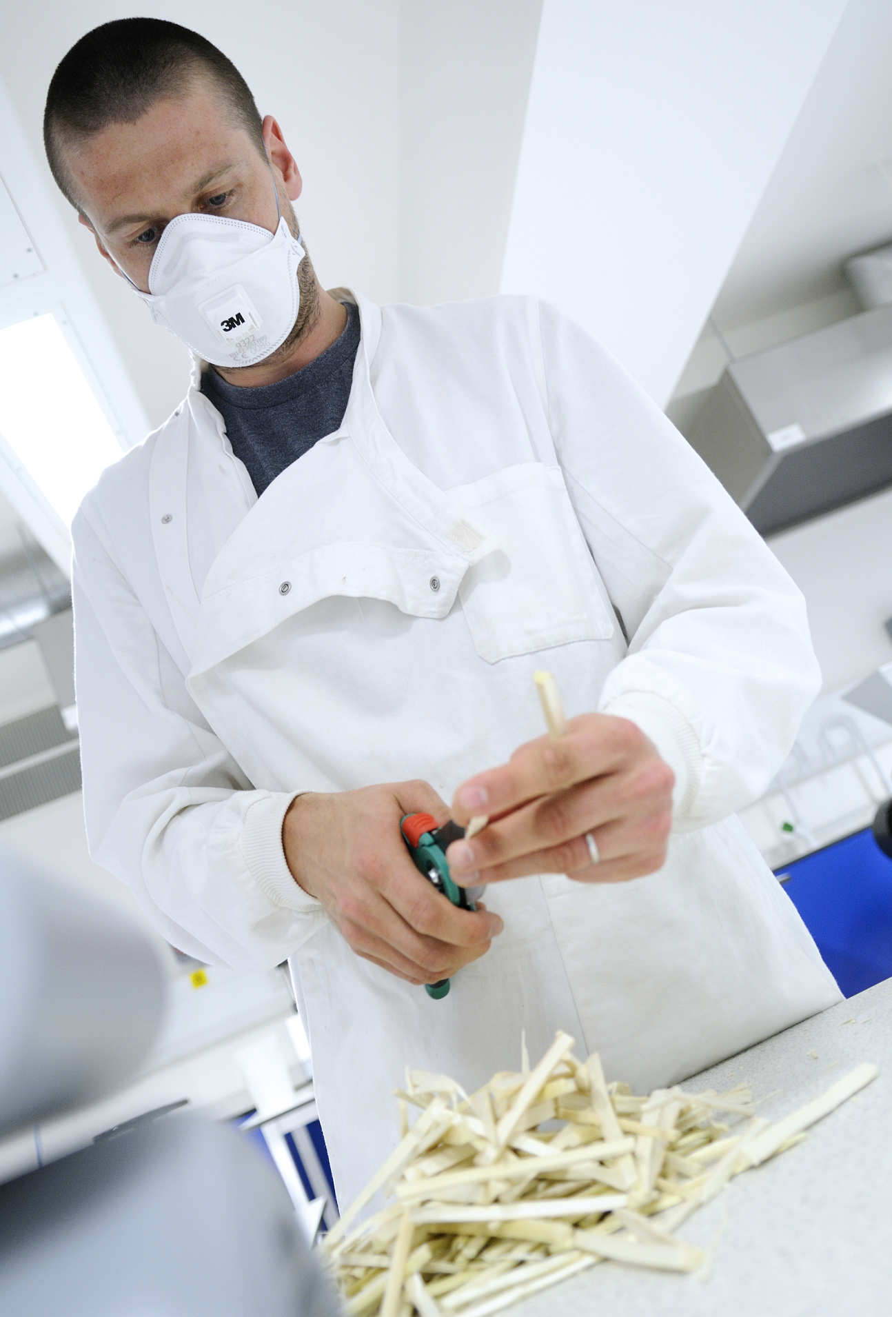 scientist with mask cutting some material