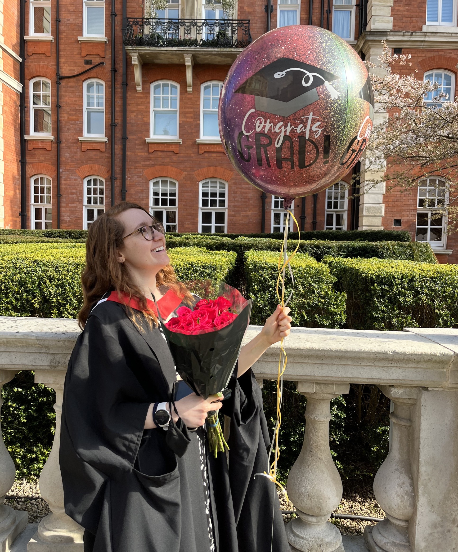 Female graduate holding a balloon