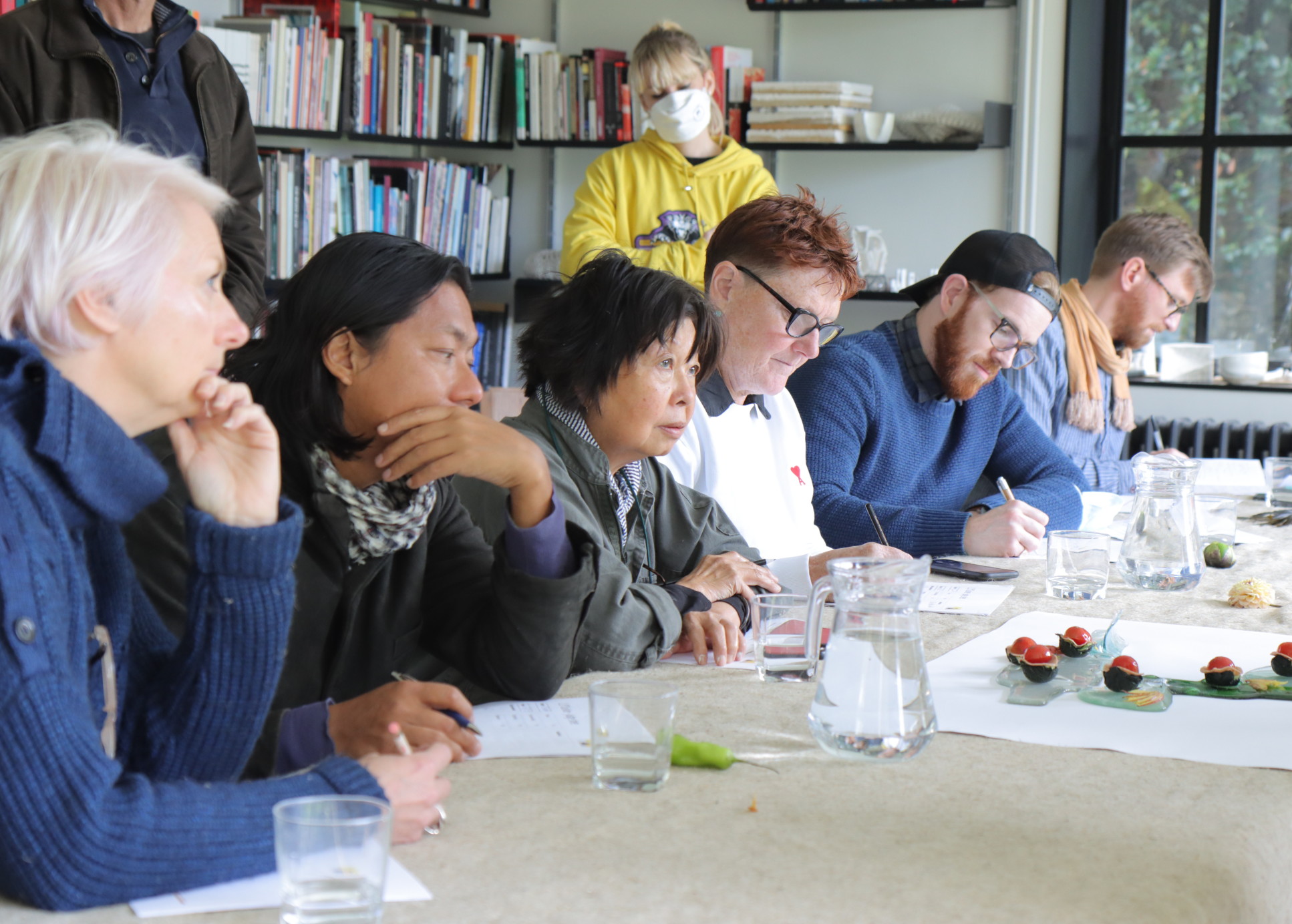 Group of male and female tutors sit at desk in a row