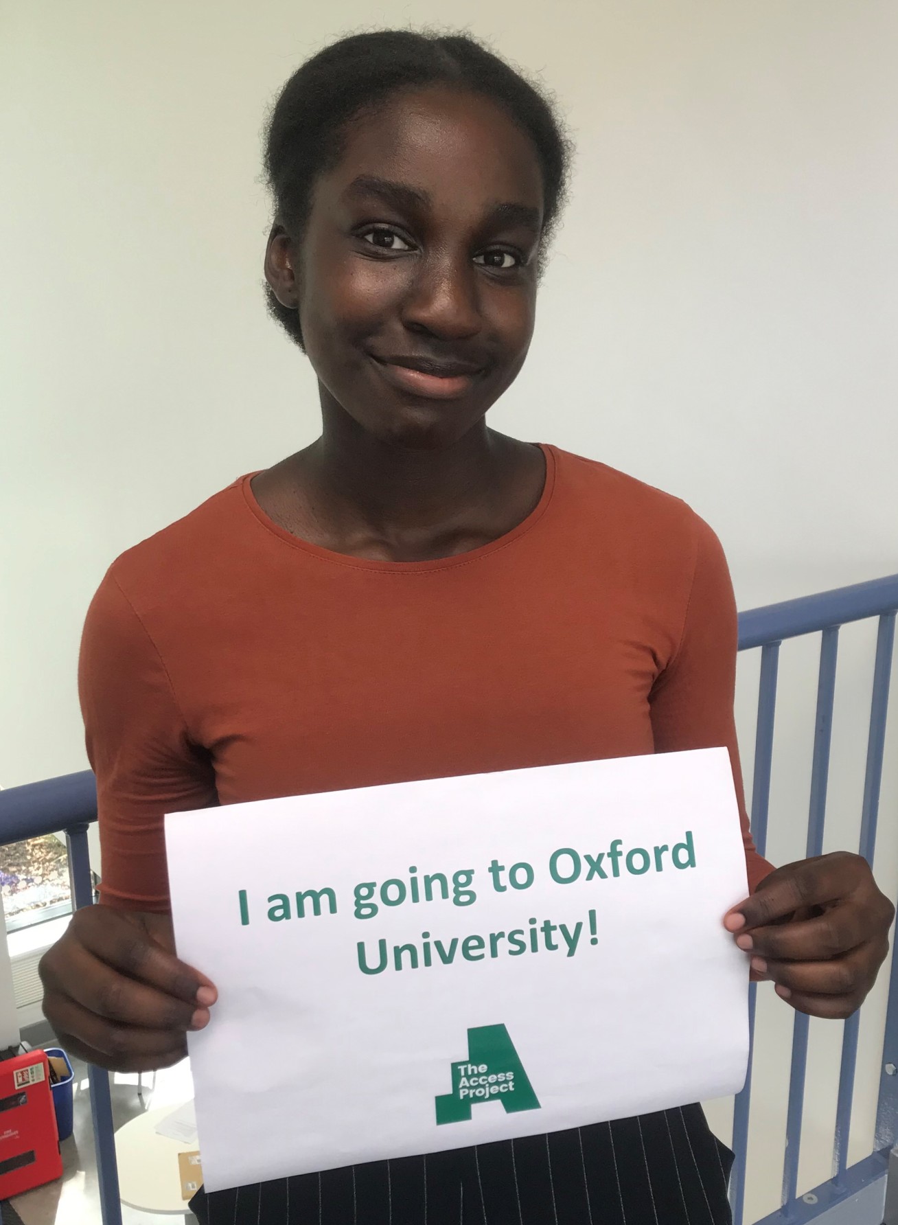 Girl holding a sign that says: 'I am going to Oxford University!'