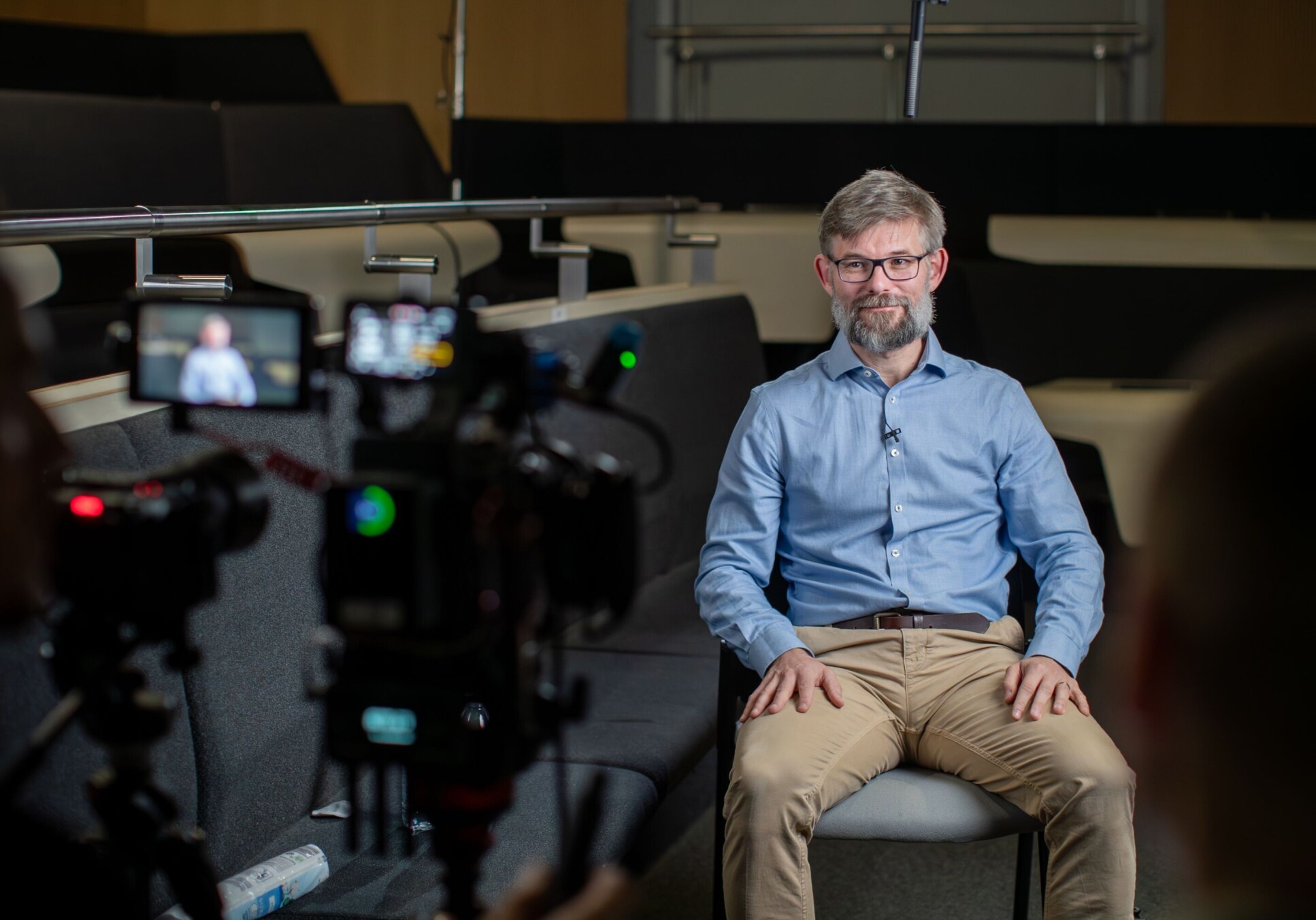 Professor Joeri Rogelj sitting ready to be interviewed seen from behind the cameras