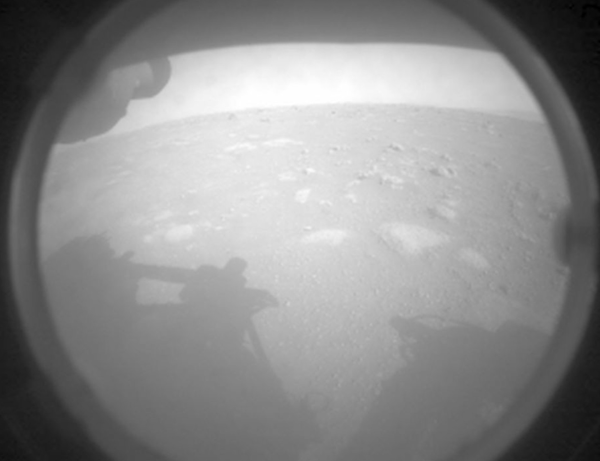 The first picture from Perseverance looks forward. The shadow comes from the rover's robotic arm. (NASA)