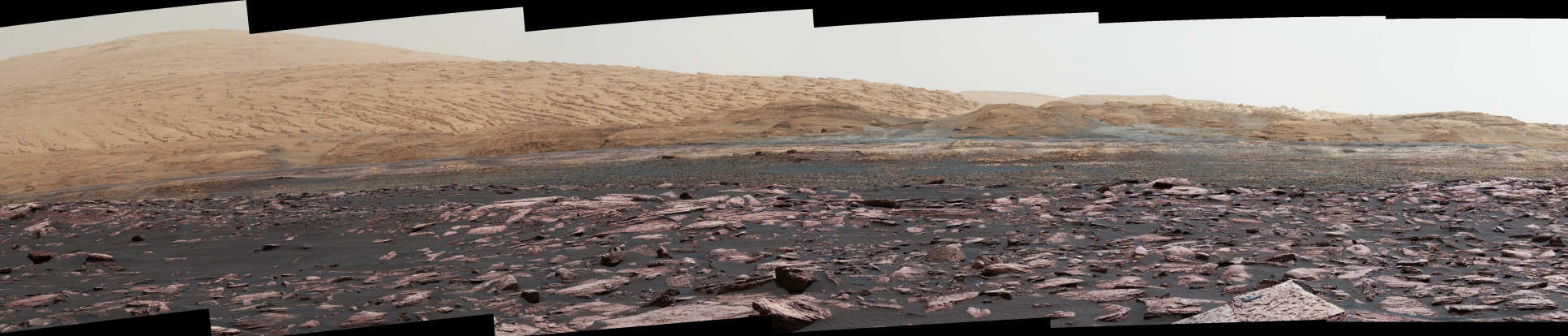 Photo taken by the Curiosity Rover on Mars showing a rocky, mountainous landscape.