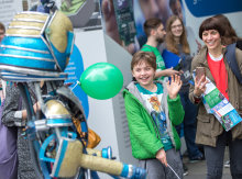 A young Festival visitor waves at a robot