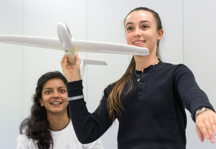 Two pupils fly a foam model aeroplane
