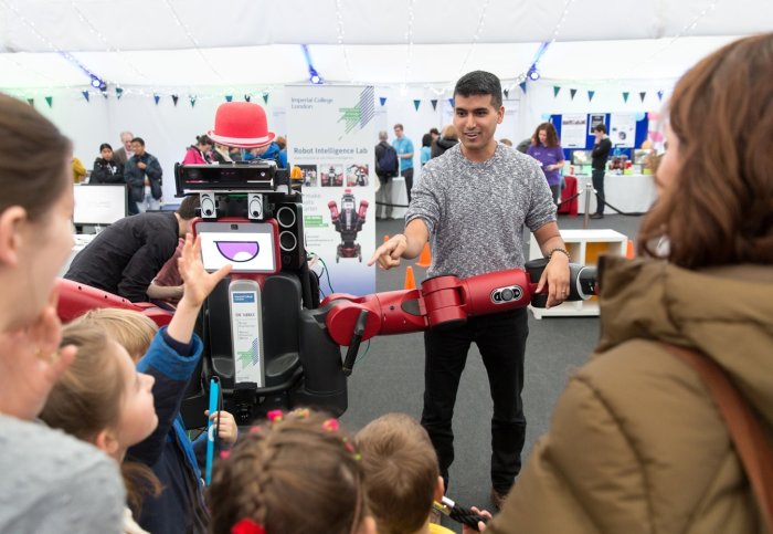 Man shows red robot to young children