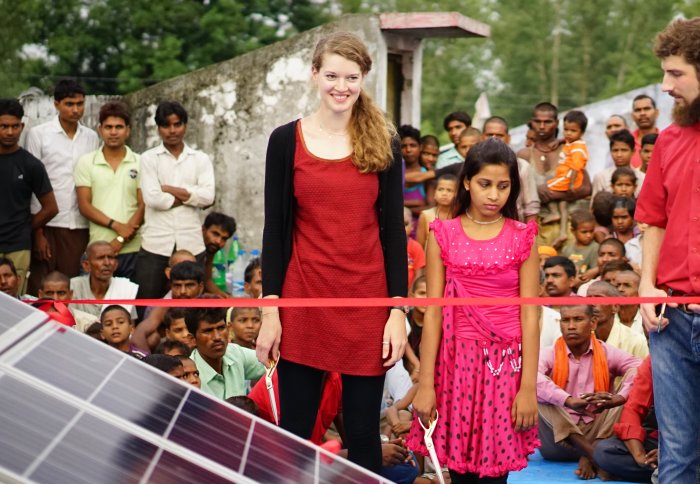 Woman and girl standing in front of solar panels
