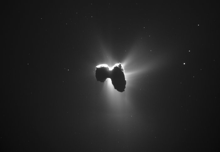 The comet on its side, its atmosphere lit from behind by the sun
