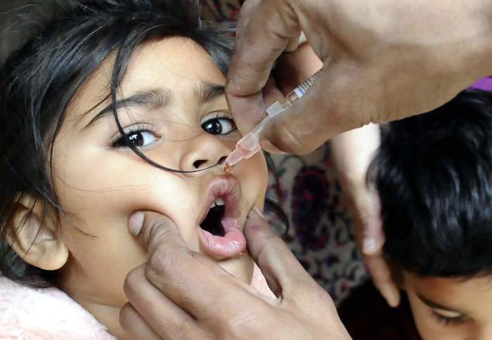 A young girl receives the polio vaccine