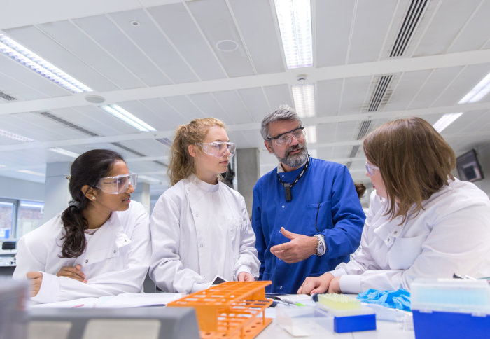 Teacher and students talk in a laboratory