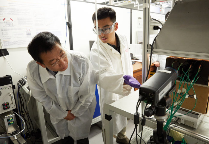 Yuqi Hu demonstrates equipment to a member of the delegation