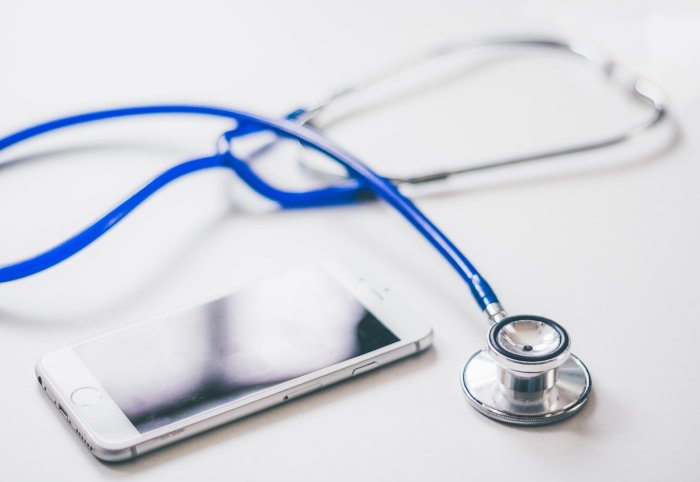 A smartphone next to a stethoscope