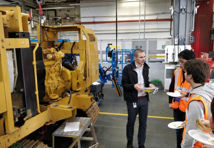 Mech Eng students discussing with Caterpillar engineers over lunch in the field test workshop