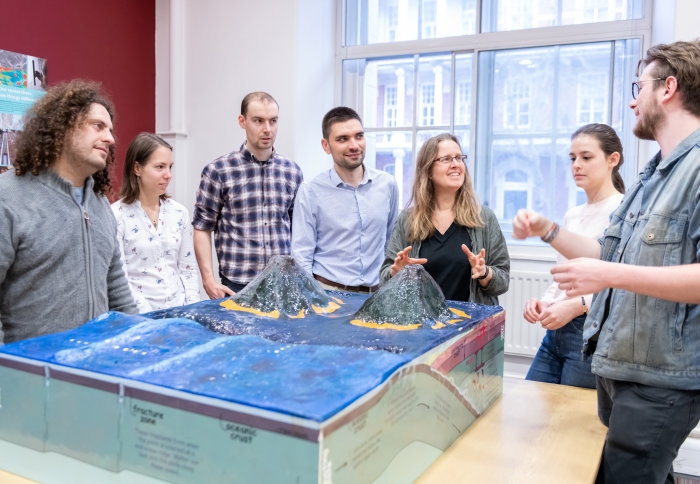 Dr Saskia Goes discussing subduction with her research group around a physical model of subducting plates