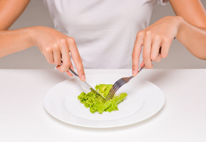 Woman eating a piece of lettuce