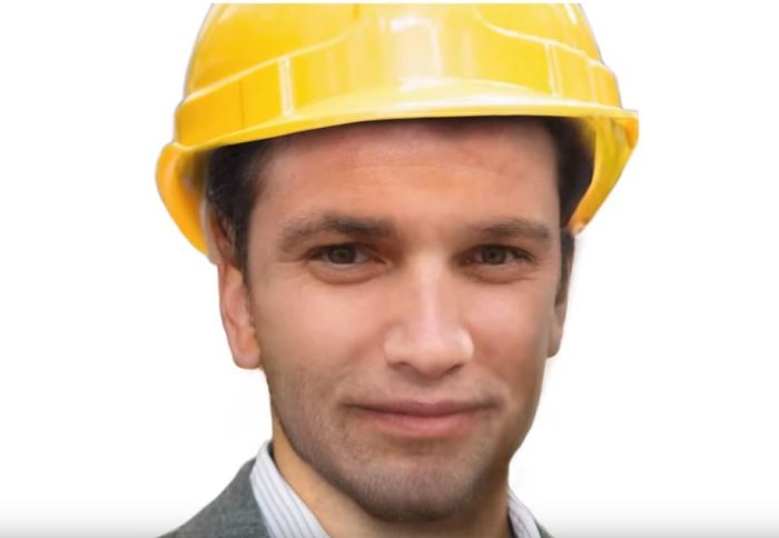 Photo of 'average face' - a white middle-aged man in a suit, with a hard hat on.