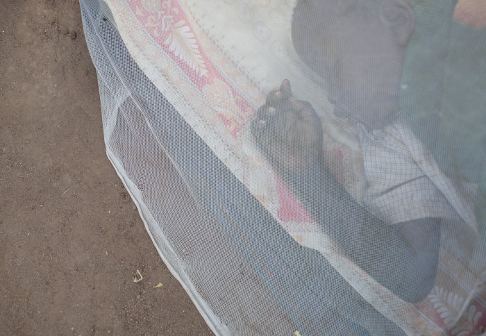 Child sleeping under a mosquito net